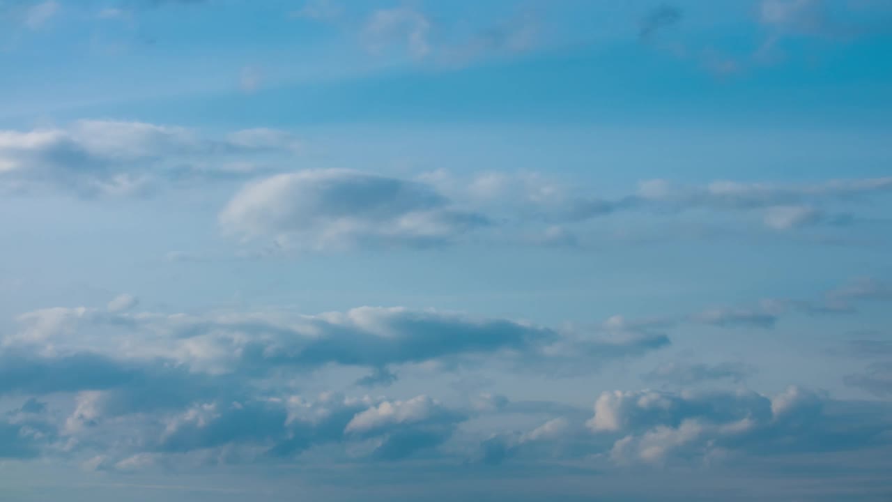 蓬松的白云在时间推移中快速移动。白昼，阴天背景。随着时间的推移，美丽的云在天空中变换，云景，云顶视频素材