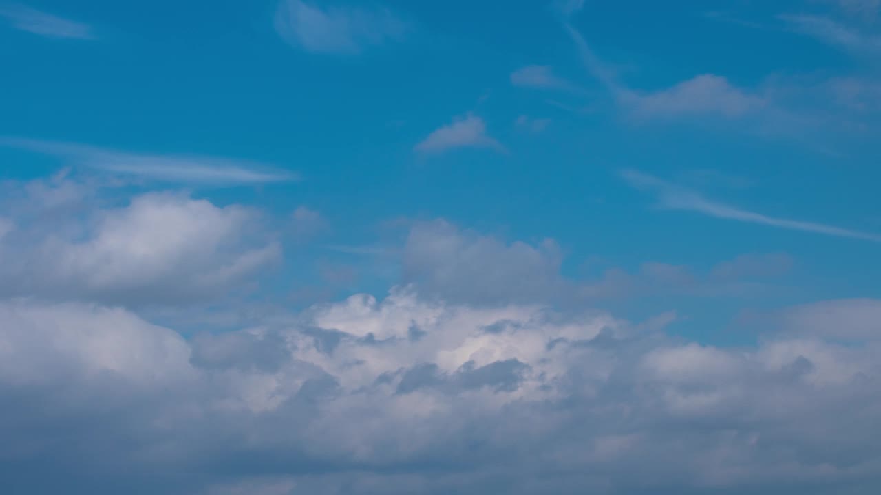 蓬松的积云在时间推移中快速移动。白昼夏日，阴天背景。随着时间的推移，美丽的云在开阔的天空中变换，云景，头顶上的云视频素材