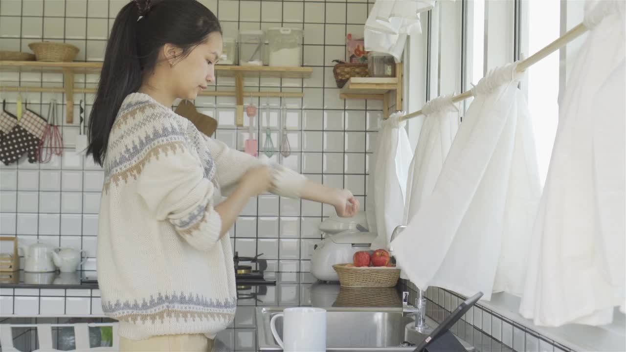 在家里厨房的水槽里洗碗的女人视频素材