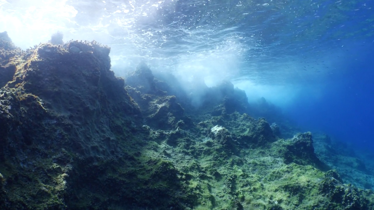 波涛汹涌的海水，波涛汹涌的海水，水下的海浪撞击着岩石，在海面上形成泡沫，形成海洋风景的背景视频素材