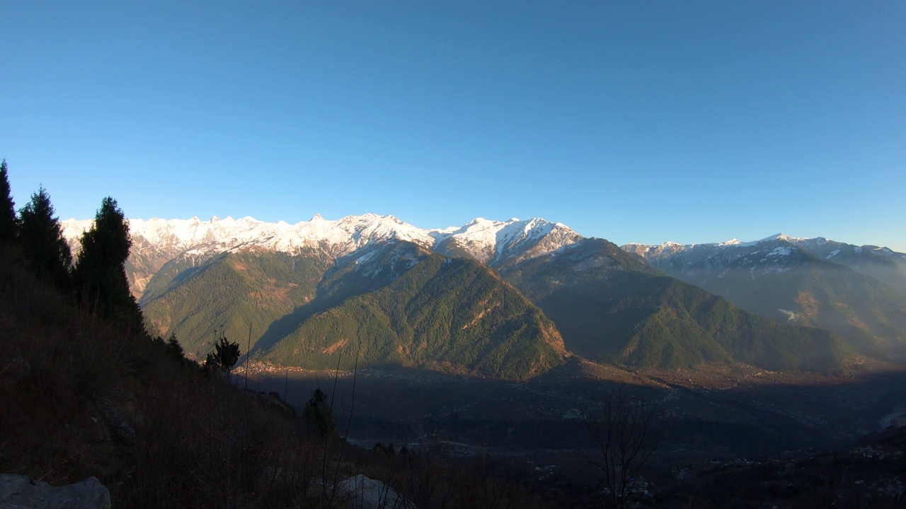 日落时分，喜马拉雅山脉积雪覆盖，4K延时拍摄。当太阳从天空落下时，阴影开始覆盖整座山。自然背景视频素材