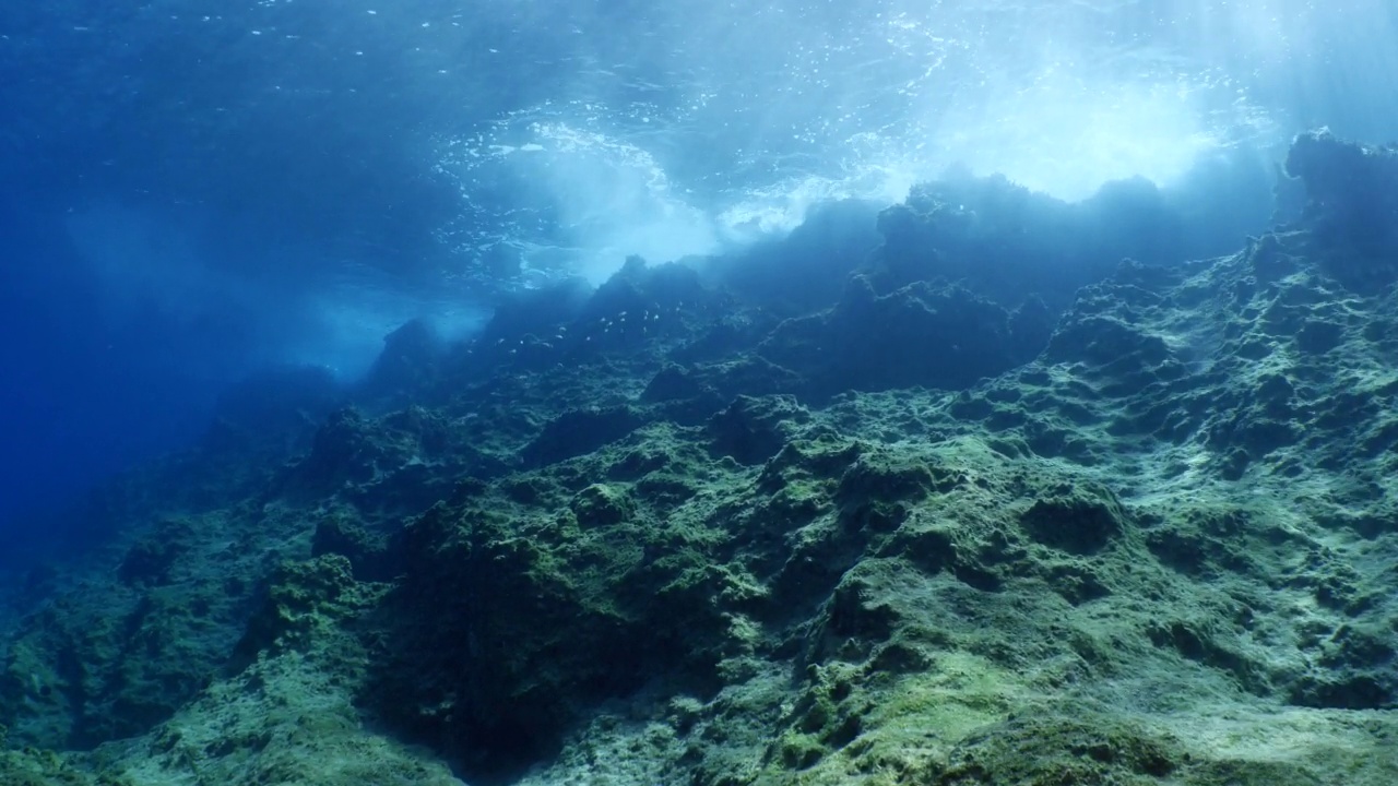 波涛汹涌的海水，波涛汹涌的海水，水下的海浪撞击着岩石，在海面上形成泡沫，形成海洋风景的背景视频素材