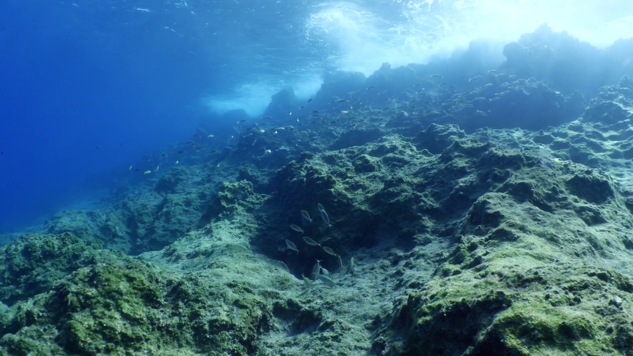 波涛汹涌的海水，波涛汹涌的海水，水下的海浪撞击着岩石，在海面上形成泡沫，形成海洋风景的背景视频素材