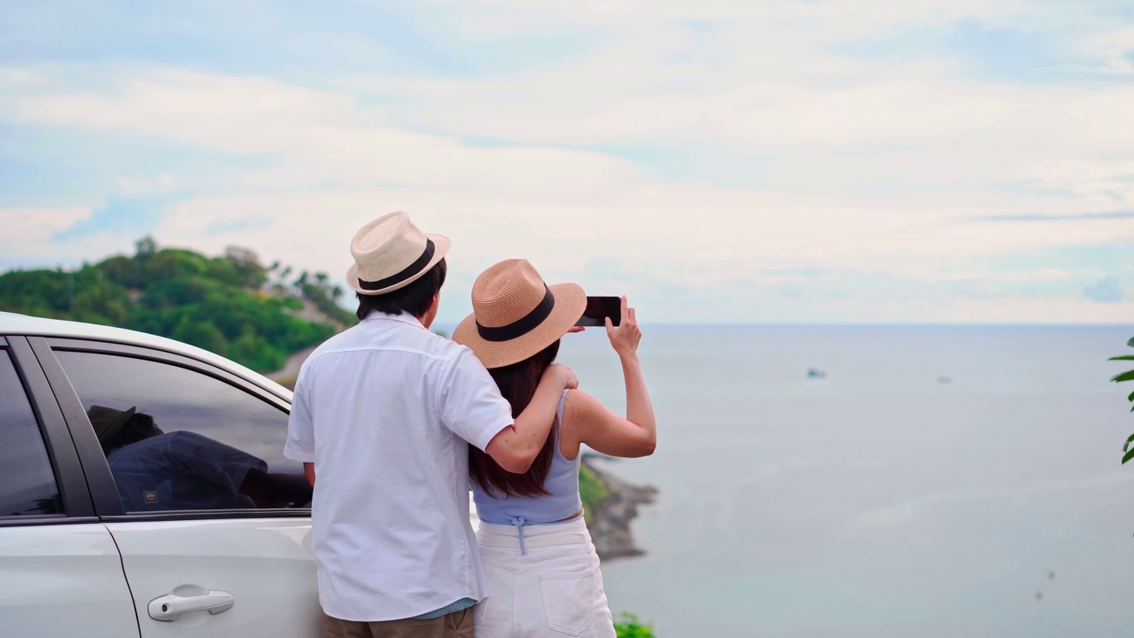 年轻夫妇的旅行看着美丽的海景与他们的汽车旅行，开车自驾游的假期视频素材