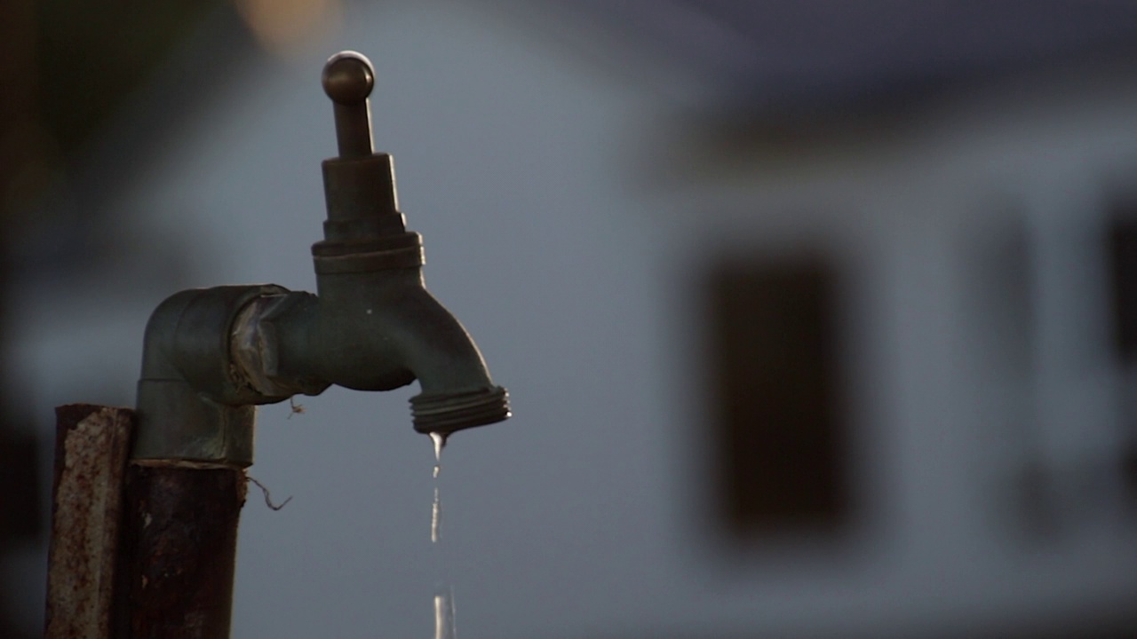 郊区一户人家后院的水龙头漏水视频素材