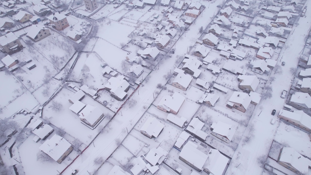 冬季鸟瞰图，雪村有私人住宅和花园地块视频素材