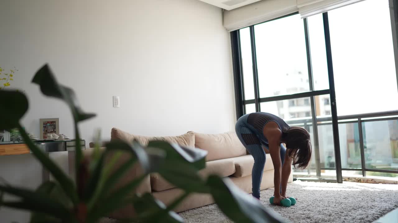 成年女性在家做举重运动视频素材