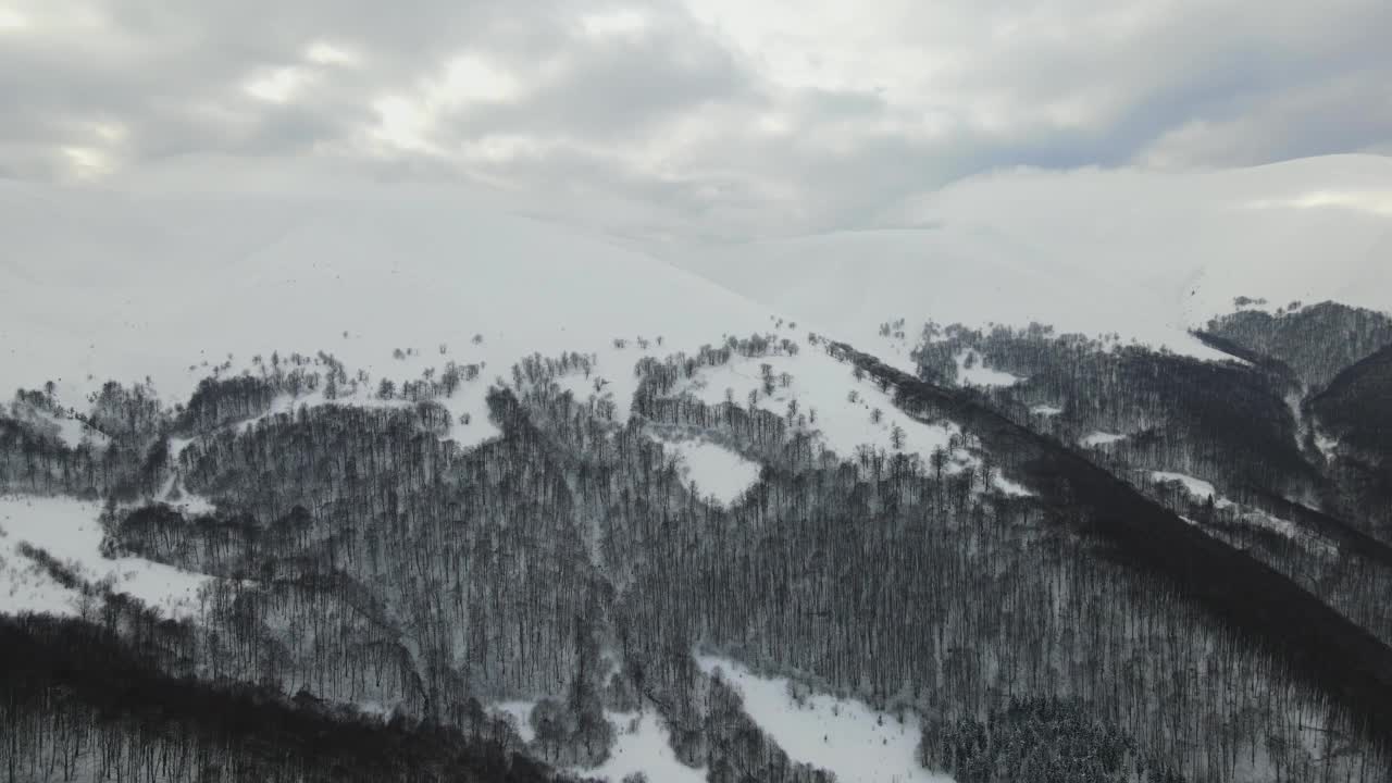 令人惊叹的空中飞行在雾蒙蒙的山脉，草地和冰雪覆盖的山峰在冬天的时间。乌克兰喀尔巴阡山脉，金巴山，4k鸟瞰图。视频素材