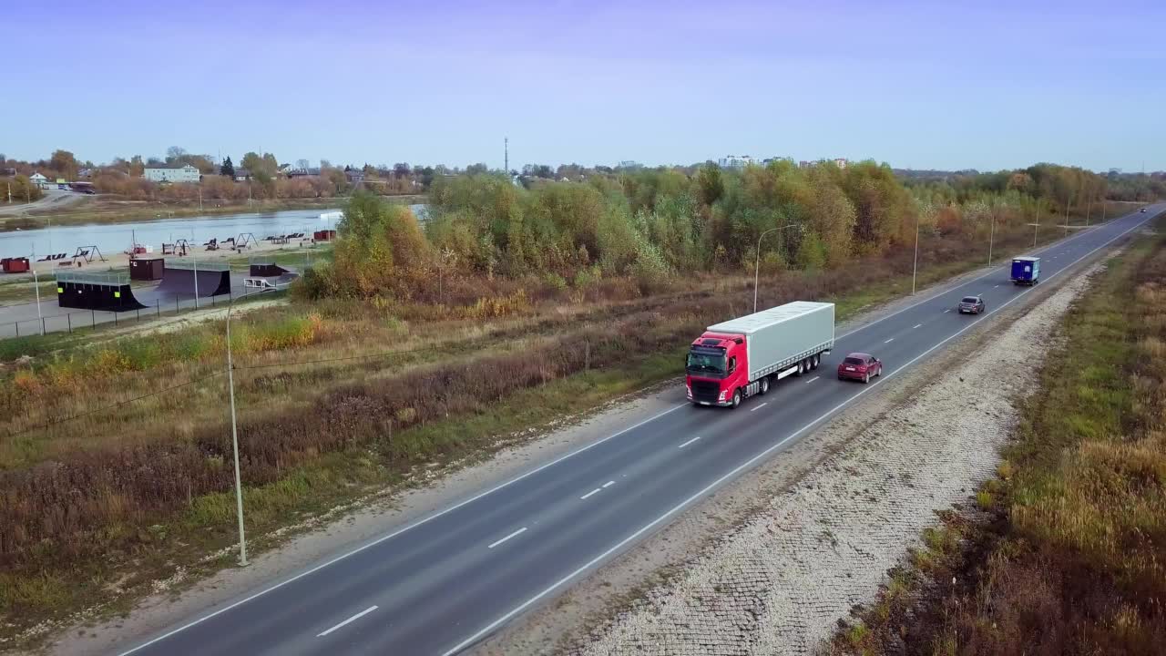 空中侧视图的卡车移动沿公路与货物拖车。视频素材