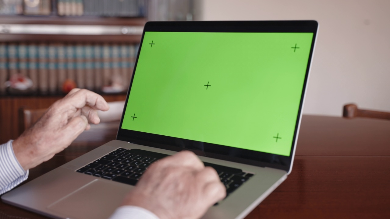 年迈的科学家在家里办公室时髦电脑的键盘上打字，在书架背景上研究项目的老人在笔记本电脑上工作。男子正在打字视频素材