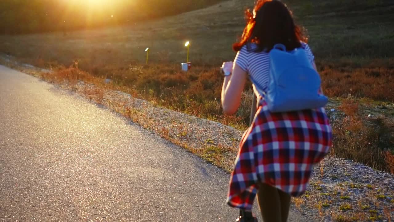 女孩背着背包骑着电动滑板车去夕阳西下，慢悠悠莫回头看视频素材