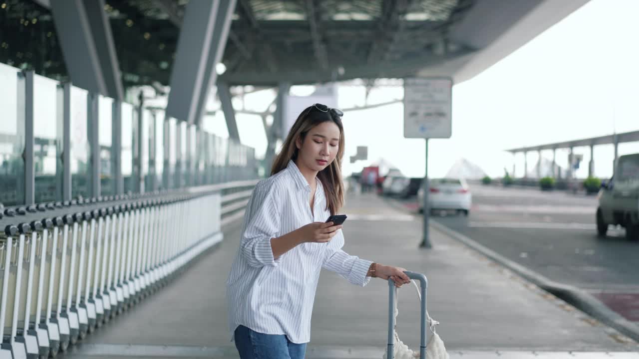 一位女性游客用智能手机叫出租车。视频素材