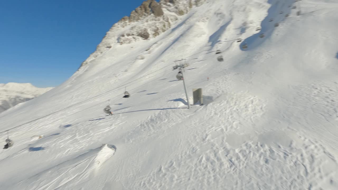 FPV无人机阳光滑雪场全景活跃的人们享受冬季极限运动户外活动视频素材