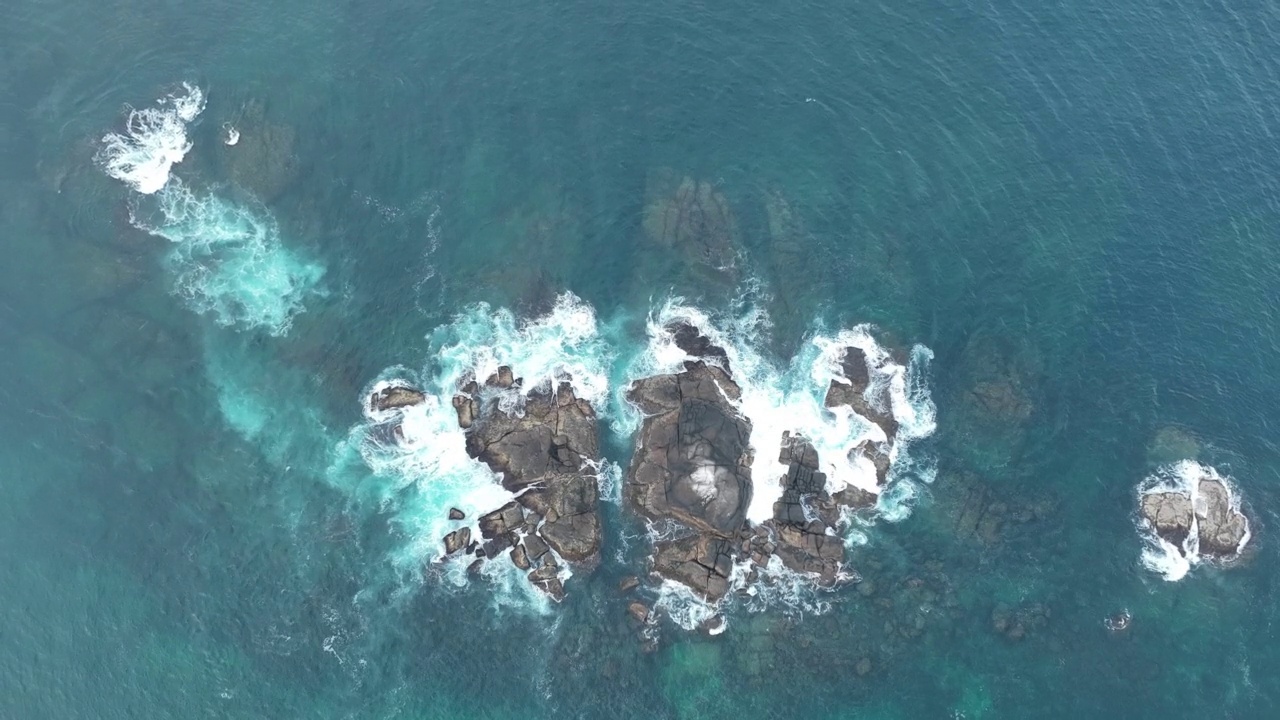 海浪撞击着海洋中的岩石。一幅宁静的自然景象。水中岩石的鸟瞰图。海洋与陆地的交汇处。慢动作120帧的视频视频素材