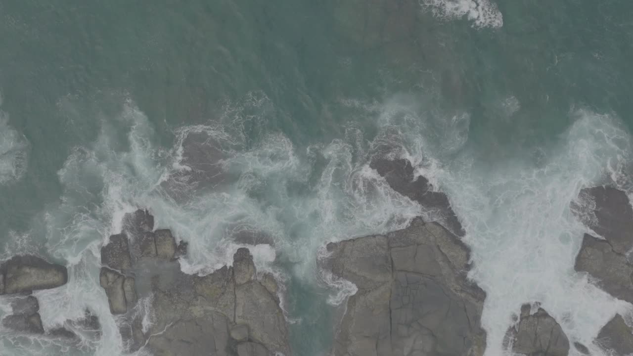 海浪撞击着海洋中的岩石。一幅宁静的自然景象。水中岩石的鸟瞰图。海洋与陆地的交汇处。120fps视频，ProRes, 10bit，未分级D-LOG视频素材