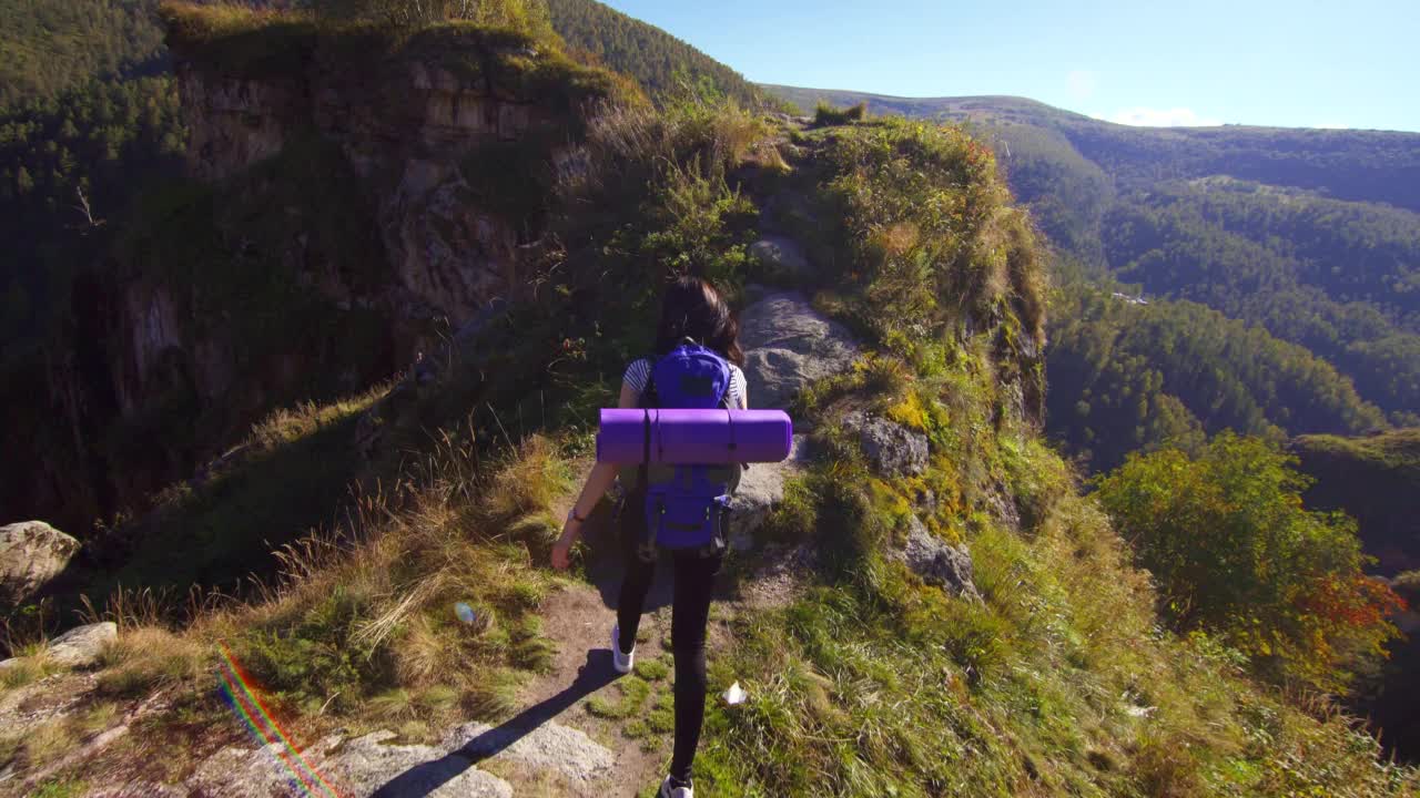 女登山者背着背包爬山，高兴地举起双手视频素材