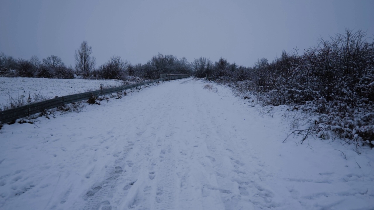 一个冬天的风景与飘落的雪慢动作，积雪的道路视频素材