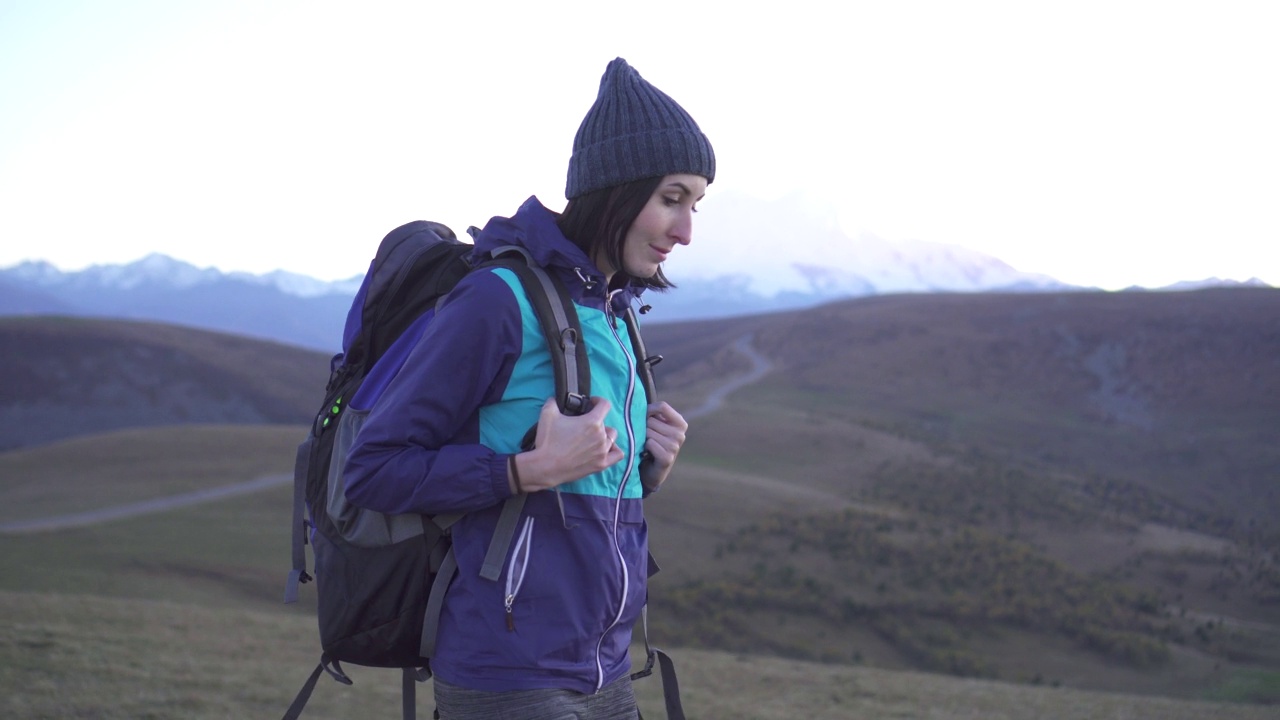 肖像坚强的女人旅行家与背包在山区视频素材