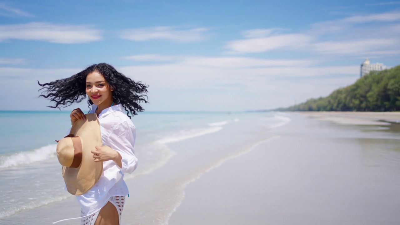 在夏日阳光明媚的日子里行走在热带海滩上的美丽非洲女人的4K肖像。视频素材