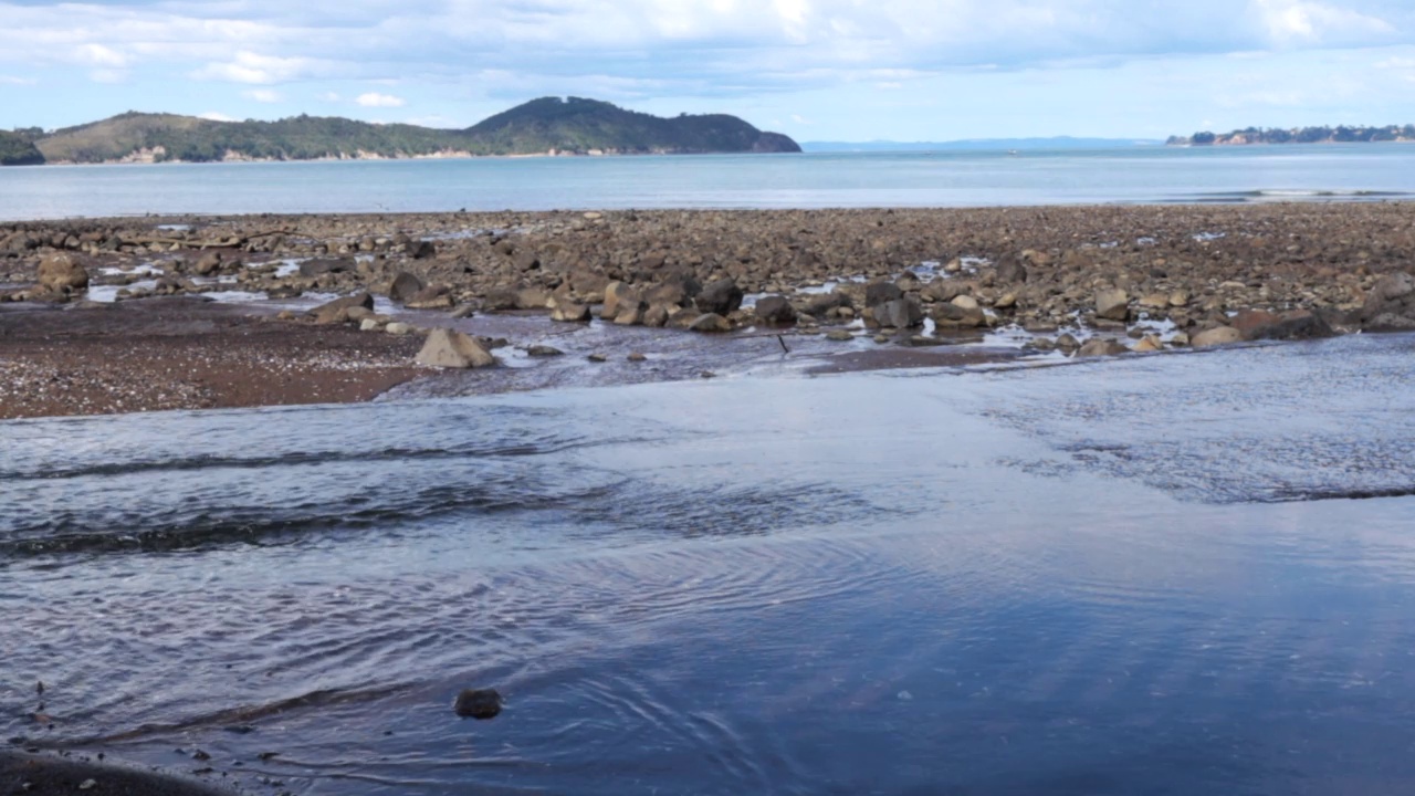 两辆汽车驶过新西兰奥克兰海岸附近的浅滩视频下载