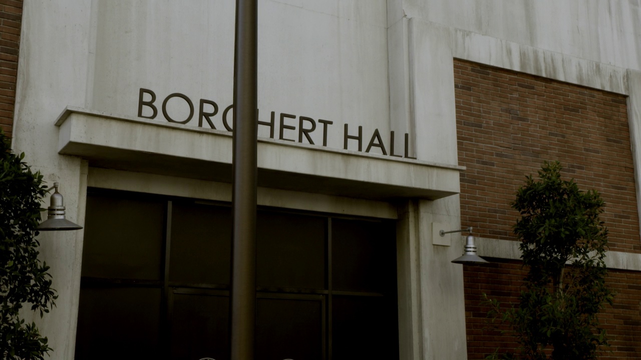 建筑入口的中角，带有“borchert hall”的标志。在fg可见旗杆。视频素材