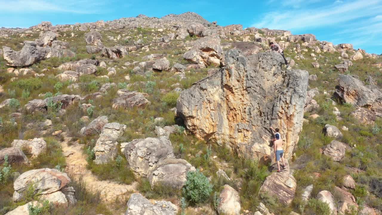 南非，在阳光明媚的偏远景观中，徒步旅行者正在攀爬岩层视频素材