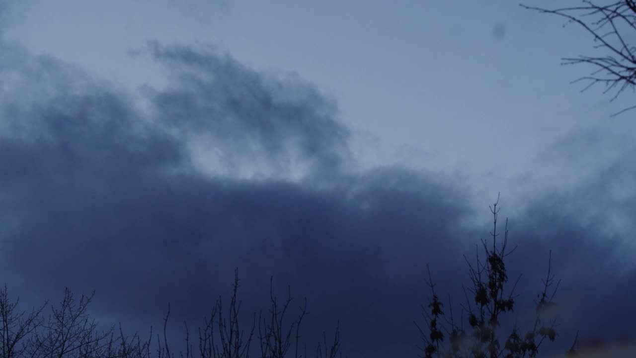 深蓝色的天空，时间的流逝。晚上飘着吓人的云，天气不好。万圣节主题视频素材