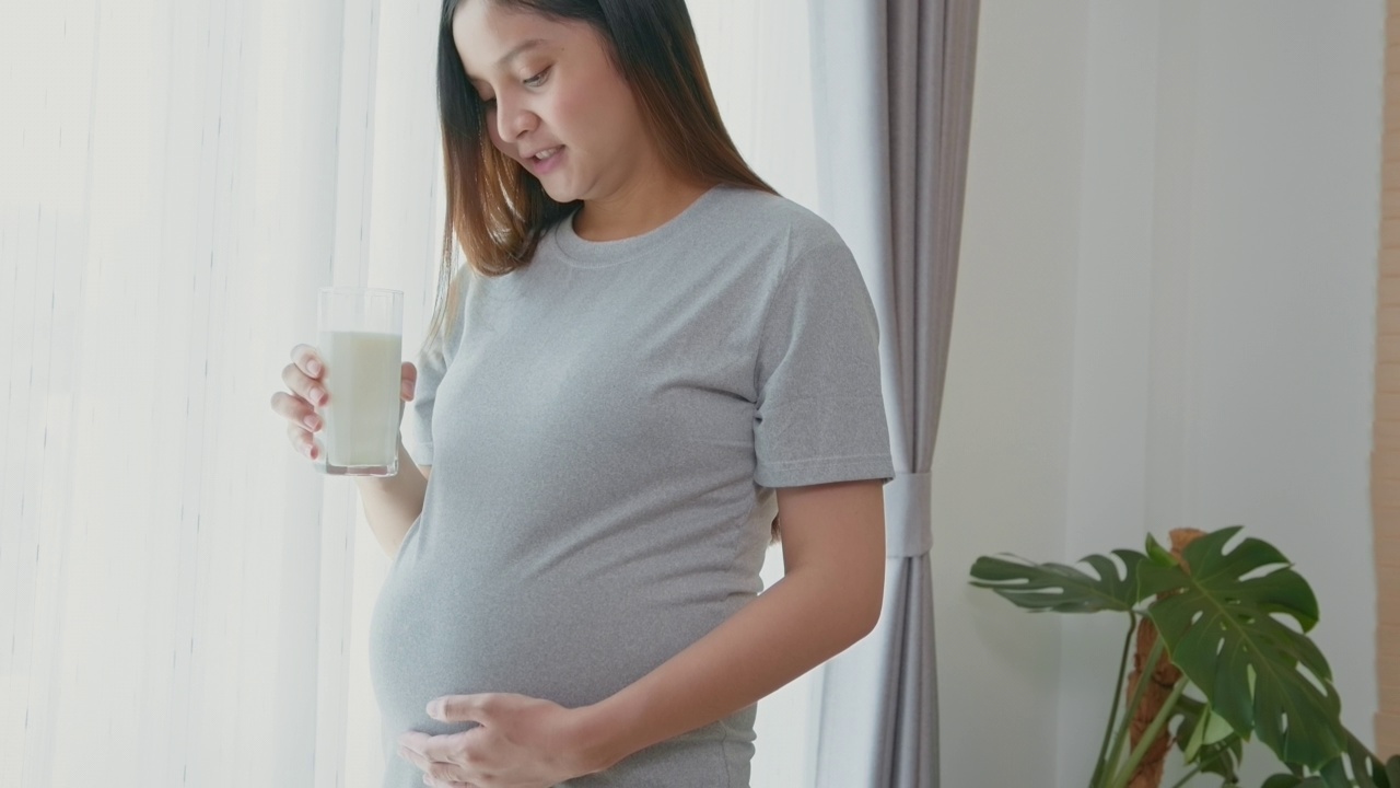 年轻孕妇在家喝牛奶，保健和孕期护理视频素材