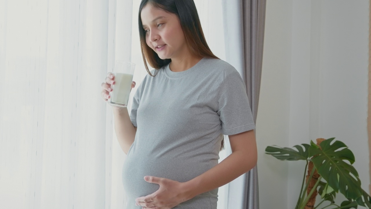 年轻孕妇在家喝牛奶，保健和孕期护理视频素材