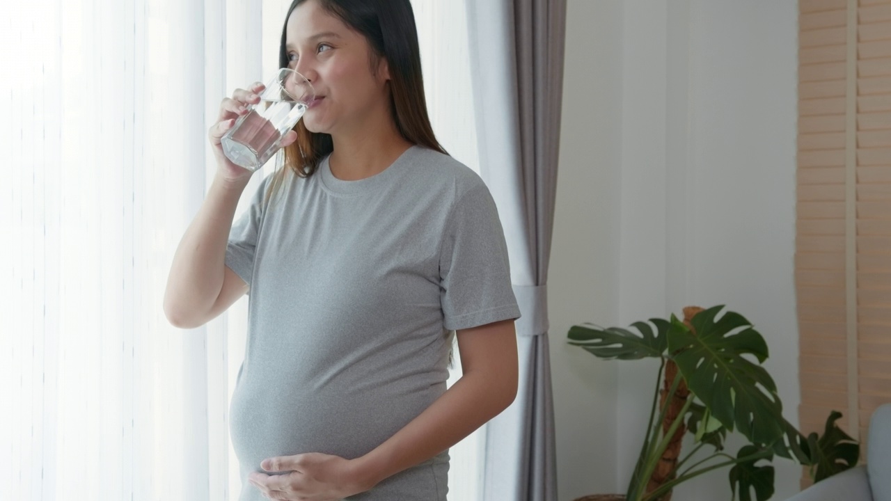 年轻孕妇在家饮水、保健和孕期护理理念视频素材