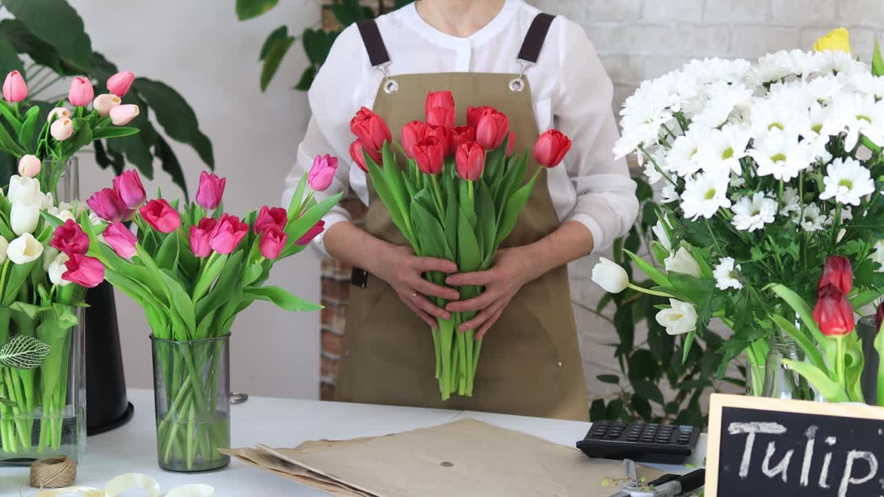 卖花的女人手里捧着一束漂亮的郁金香视频素材