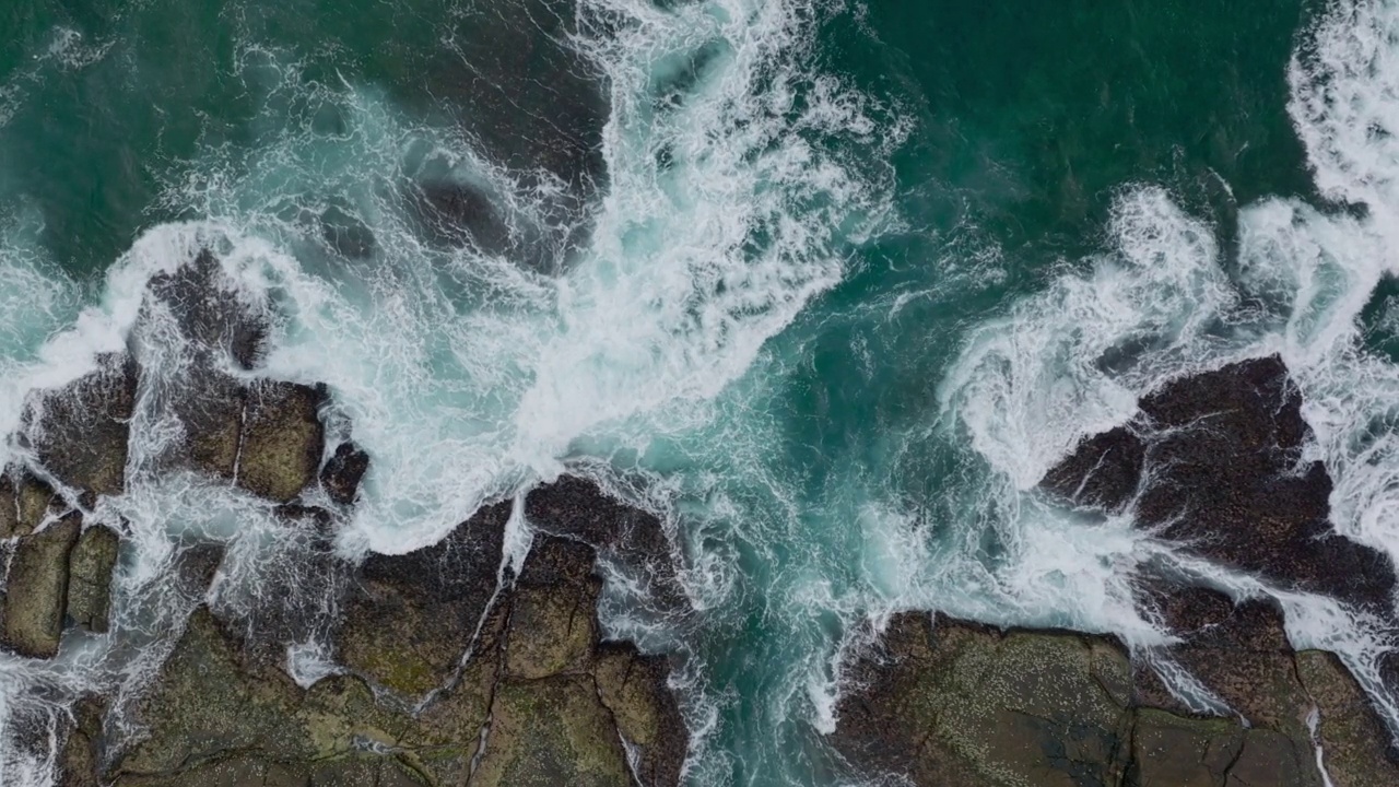 海浪撞击着海洋中的岩石。一幅宁静的自然风景。水中岩石的鸟瞰图。海洋和陆地的交汇处。120帧/秒的视频视频素材