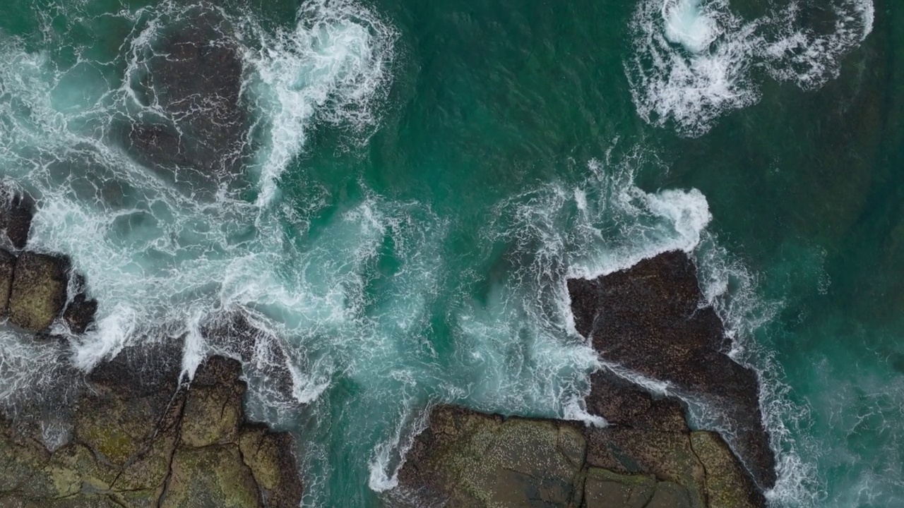 海浪撞击着海洋中的岩石。一幅宁静的自然风景。水中岩石的鸟瞰图。海洋和陆地的交汇处。120帧/秒的视频视频素材