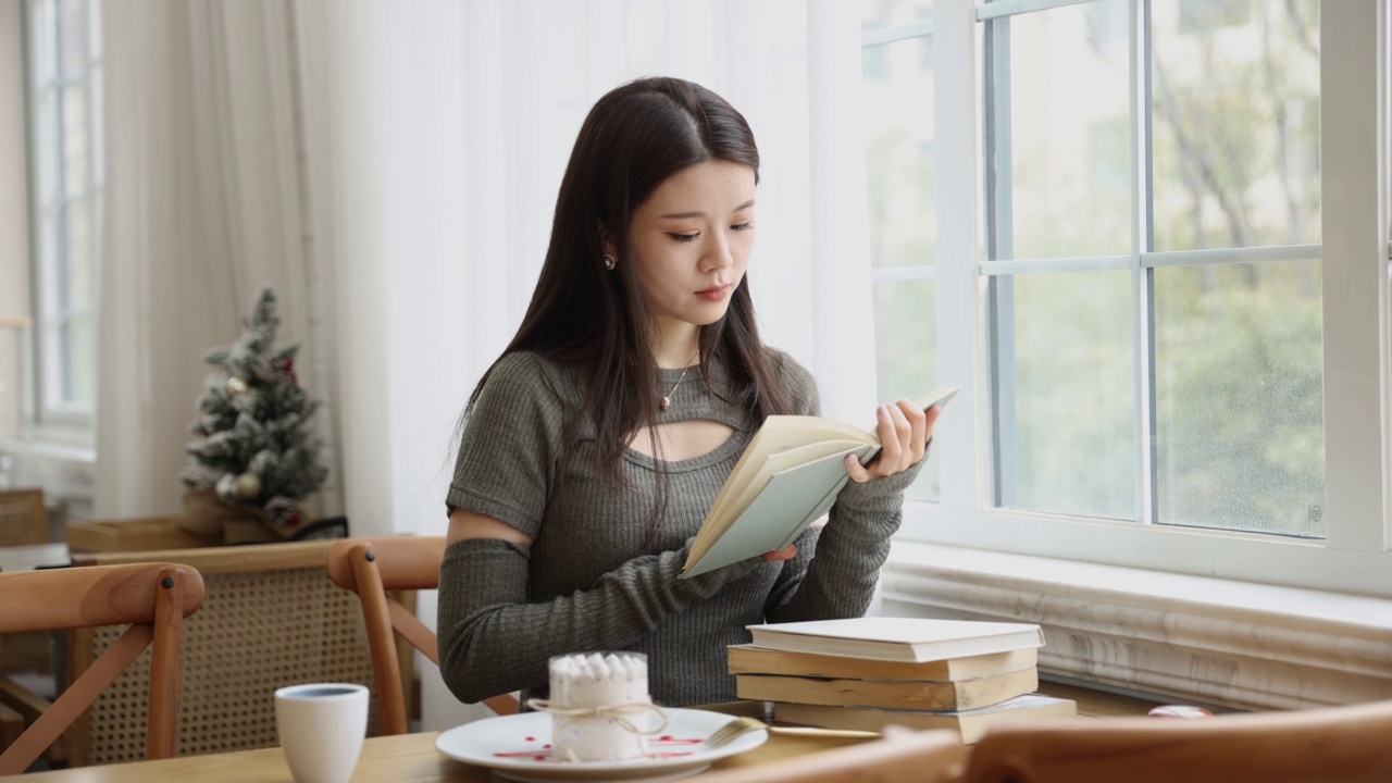 年轻女子在咖啡馆里看书视频素材