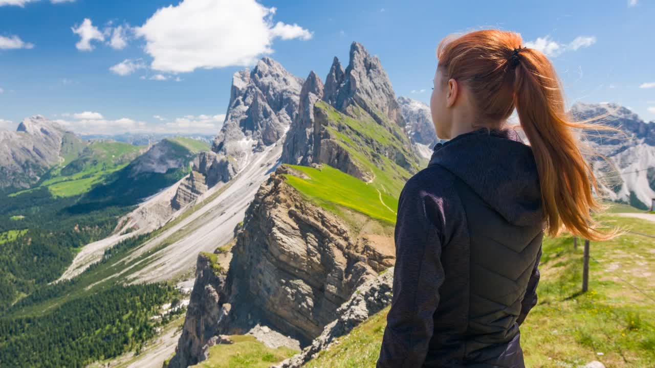 年轻的女子徒步旅行享受从塞塞达山山顶在白云石，意大利，微笑着对着相机视频素材