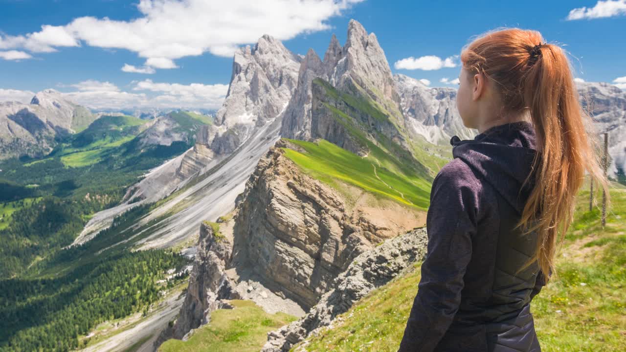 年轻的女子徒步旅行享受从塞塞达山山顶在白云石，意大利，微笑着对着相机视频素材