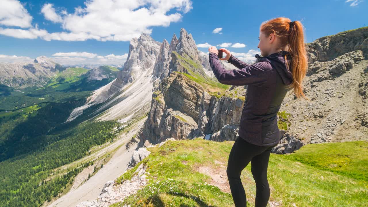 女徒步旅行者在山顶上用智能手机拍摄令人惊叹的景色视频素材