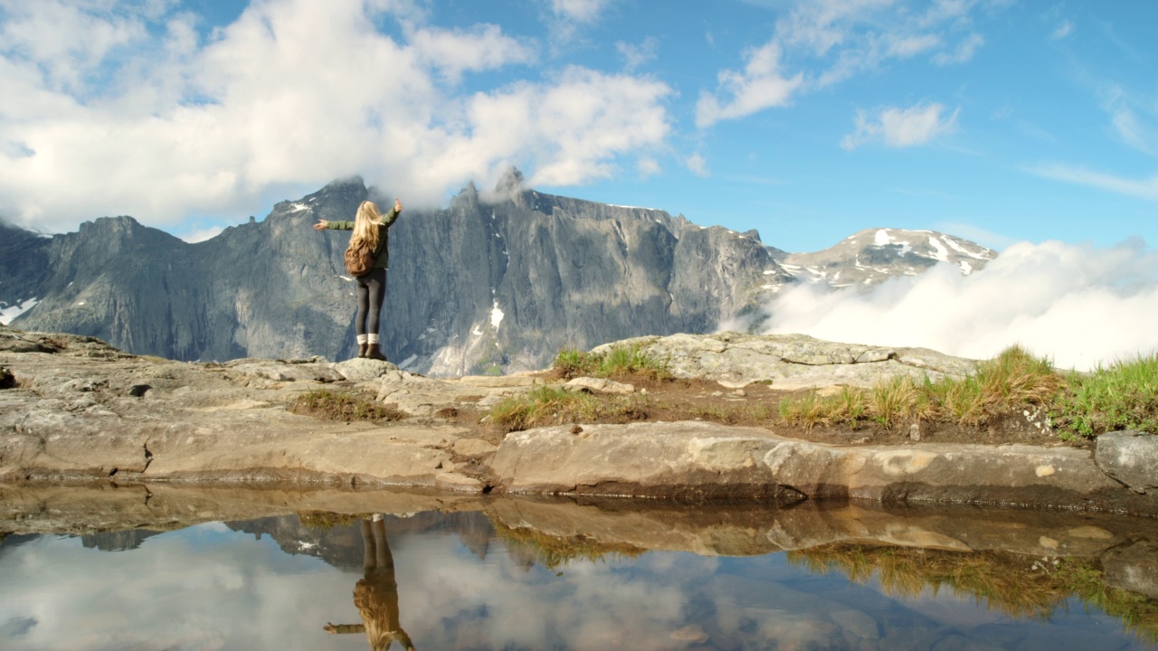 在Møre og Romsdal徒步旅行期间，一名难以辨认的女子欣赏山景的4k视频视频素材