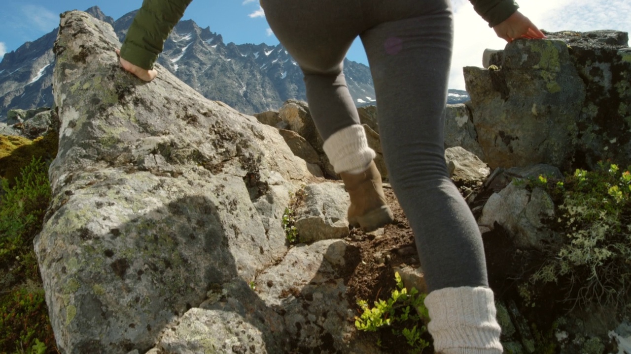 在Møre og Romsdal徒步旅行期间，一名难以辨认的女子欣赏山景的4k视频视频素材