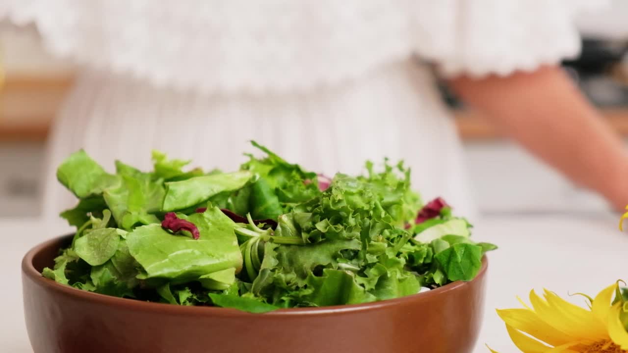 一个女人往沙拉里倒油的特写镜头视频素材