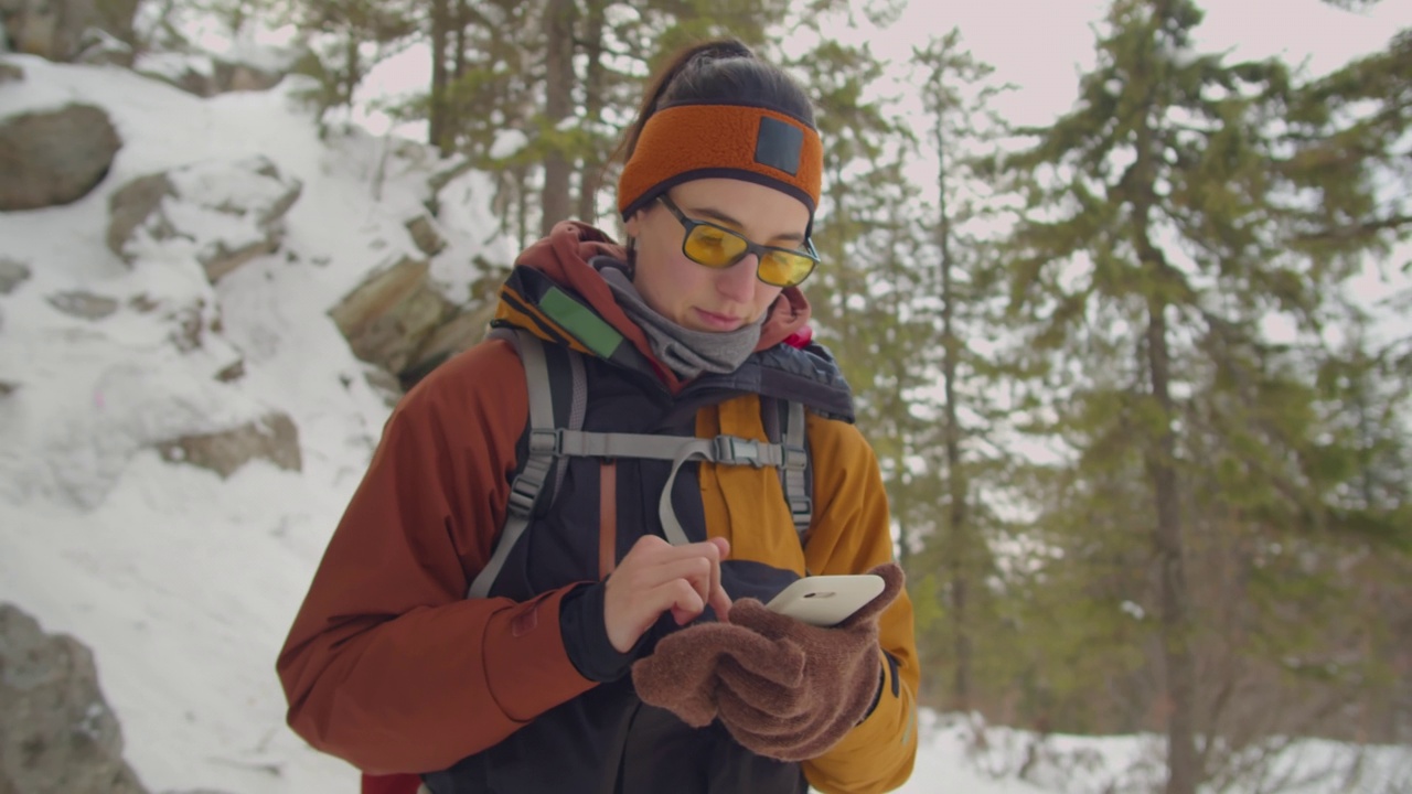 一名女子在冬季徒步旅行时使用手机地图视频素材