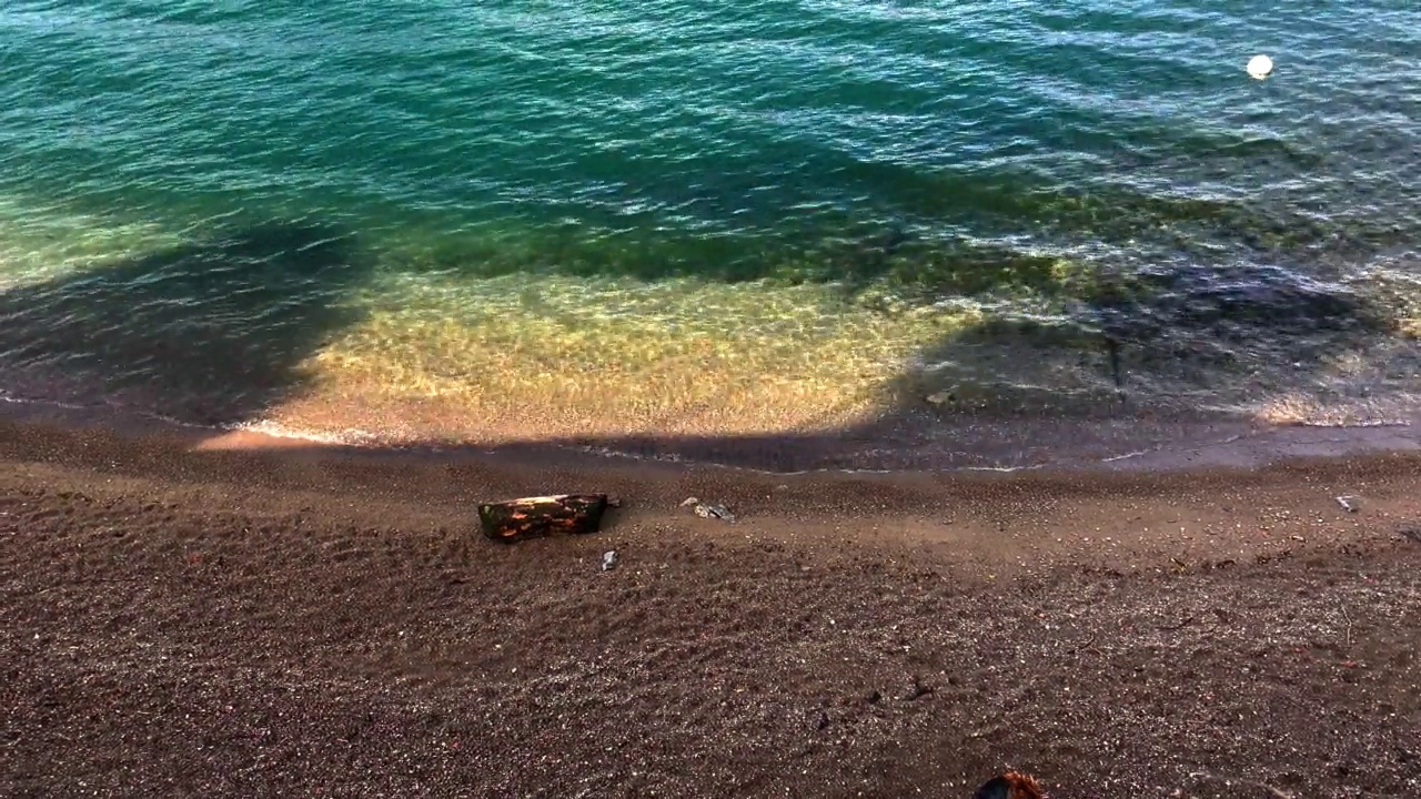 湖岸边的海滩和碧绿纯净的水与波浪的特写。视频素材