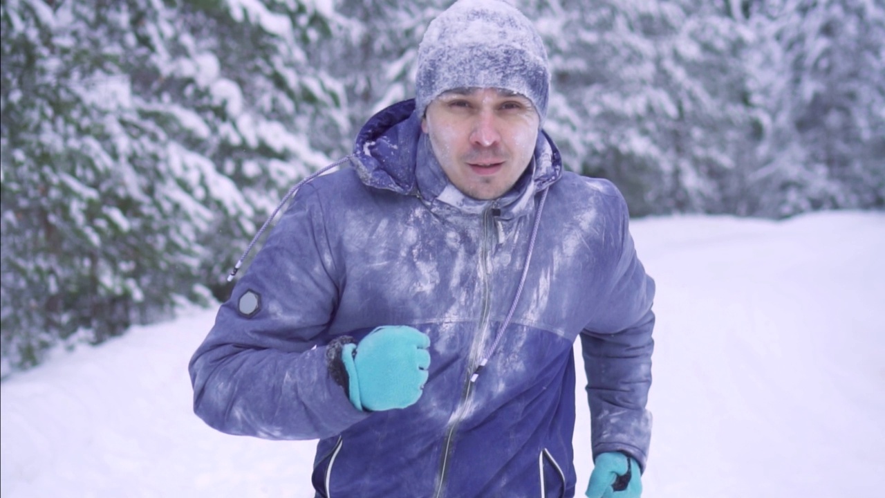 肖像冻男运动员穿越雪域森林，冬季活动视频素材