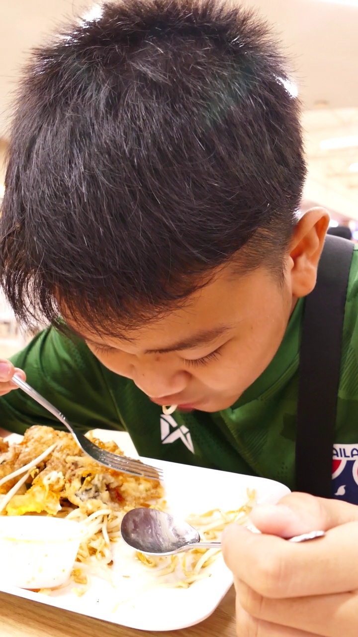 男孩们在餐桌上开心地吃着食物视频素材