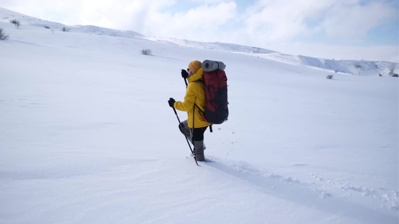 冬天背着背包在山上徒步旅行的男人视频素材