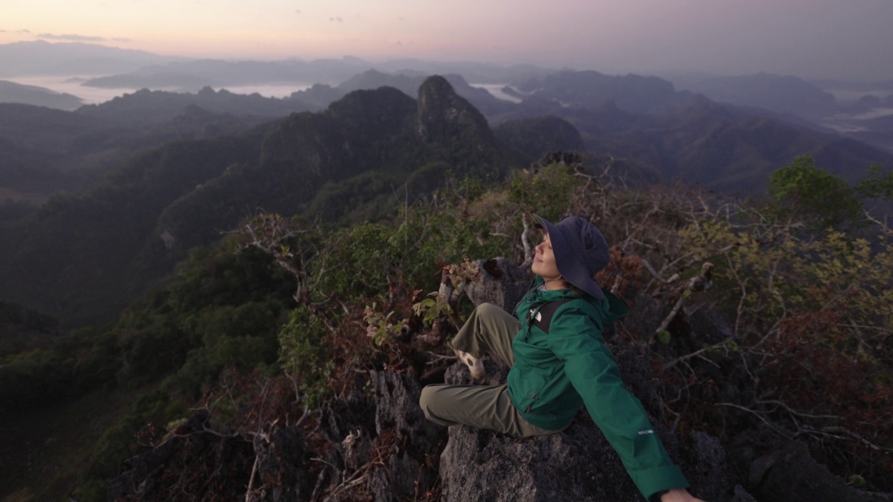 在山顶徒步旅行的女人，手举在头上庆祝成功视频素材