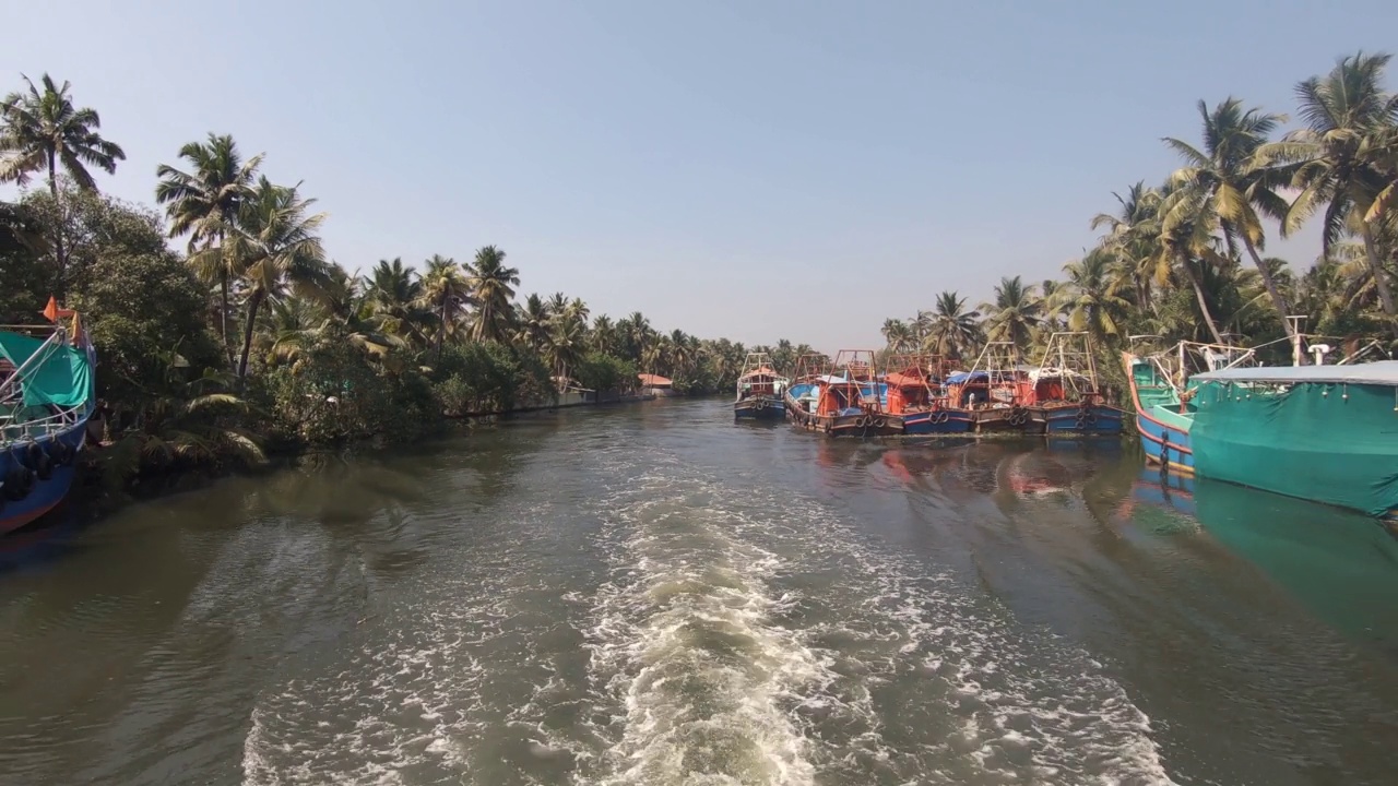 印度Alappuzha或Alleppey，渔船停泊在可航行的运河岸边。向后射击视频素材