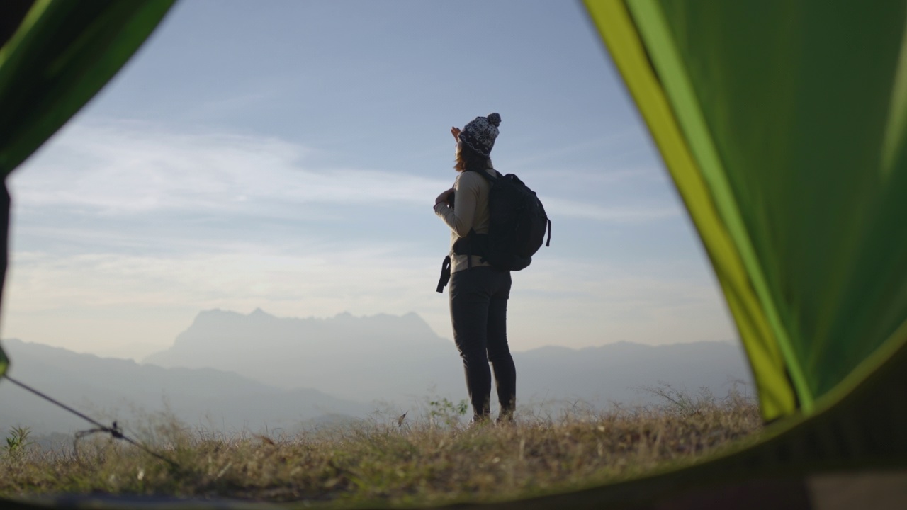 在山顶徒步旅行的女人，手举在头上庆祝成功视频素材