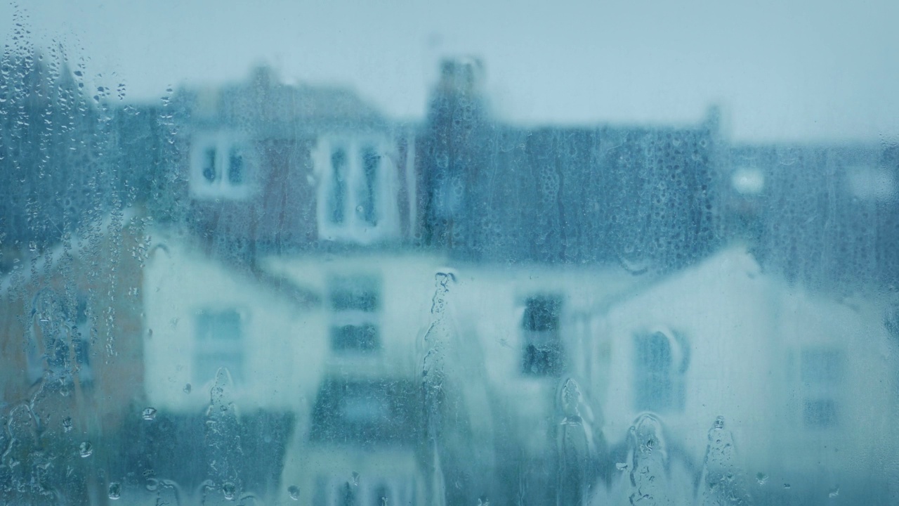 雨水打在窗户上，房子在后面失去焦点视频素材