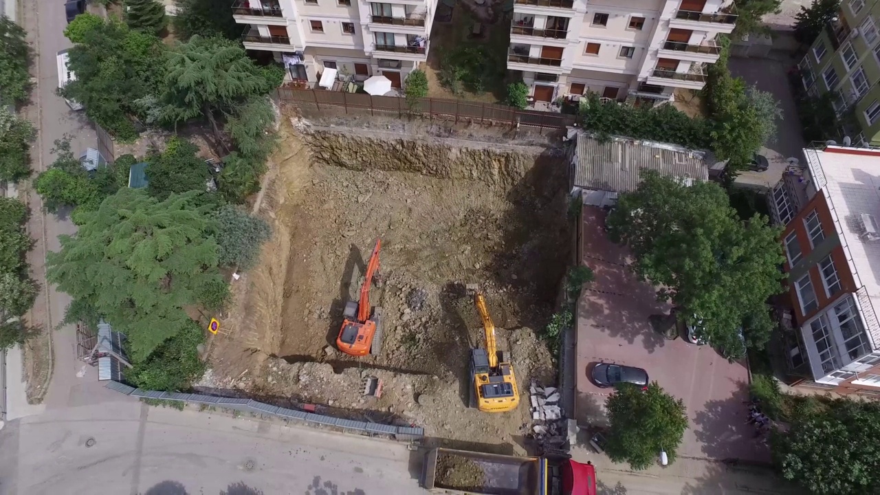 用两辆挖土机俯视拆卸地盘的影像-在建筑地盘工作的工业机械。许多拖拉机在工作时移动沙子和泥土。股票视频视频素材